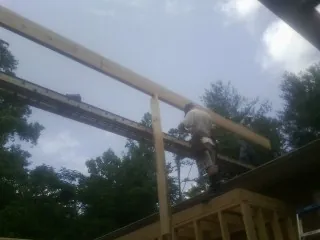 Carpenter setting a ridge beam over a new addition frame — Ice Dam Removal by Roofing Brothers in Holland